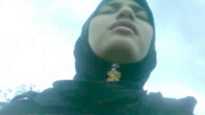 A charming girl wearing a hijab reveals her breasts and genitals