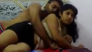 A youthful pair engages in intimate activities on the bed